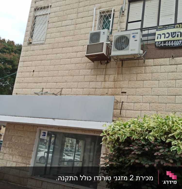 שני מזגנים מותקנים על קיר חיצוני של בניין